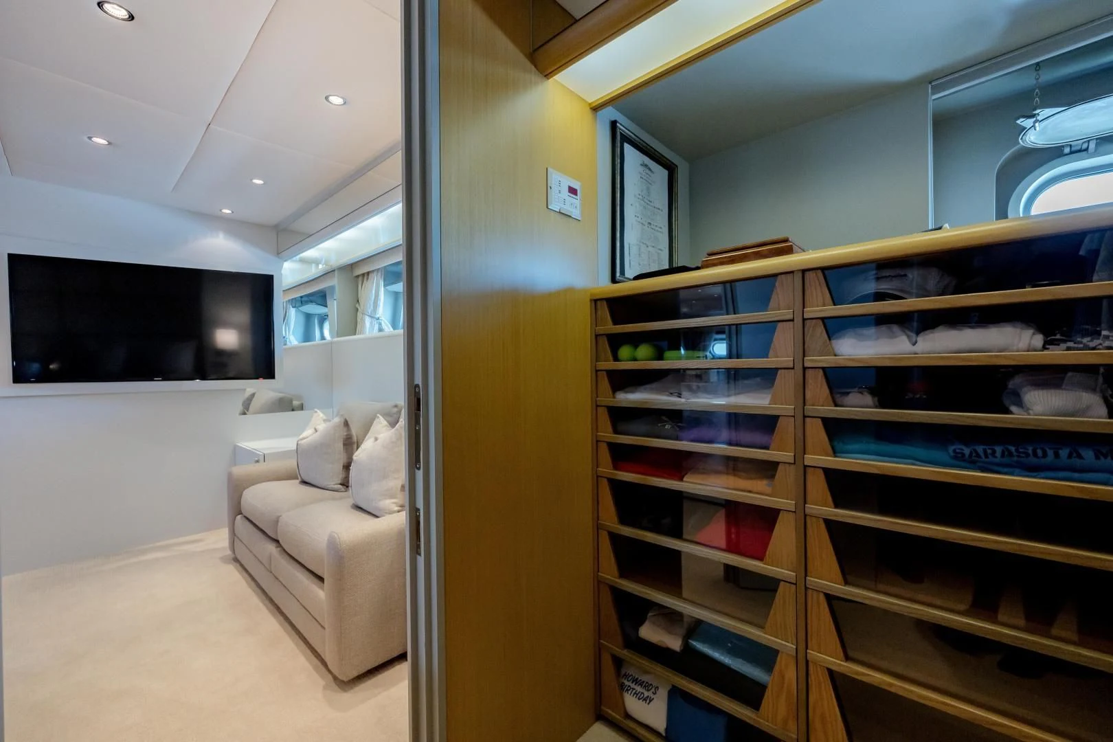 a room with a couch and a shelf with books on it aboard DREAM RIDER Yacht for Sale