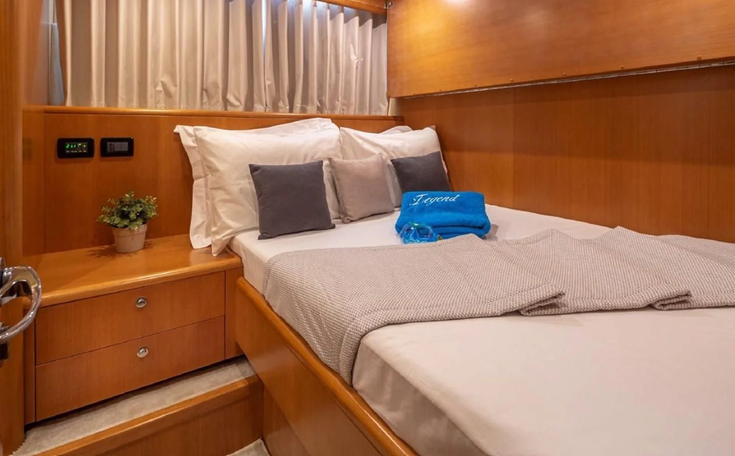 a room with a bed and a dresser aboard LEGEND Yacht for Sale