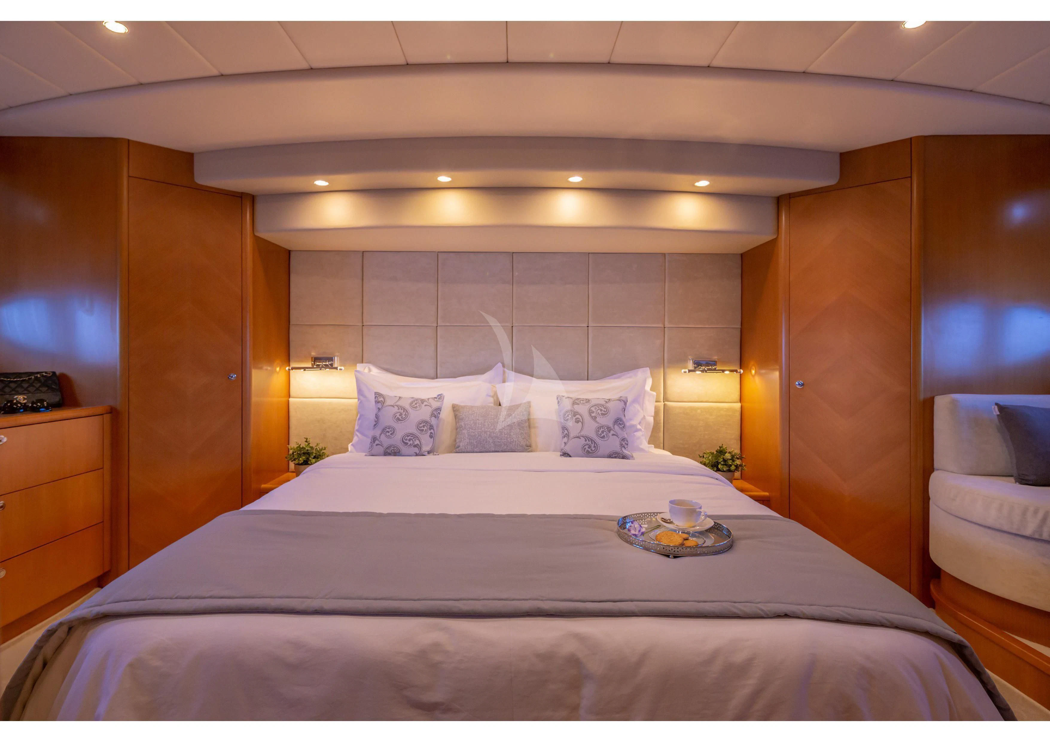 a bed with a white bed spread aboard LEGEND Yacht for Sale