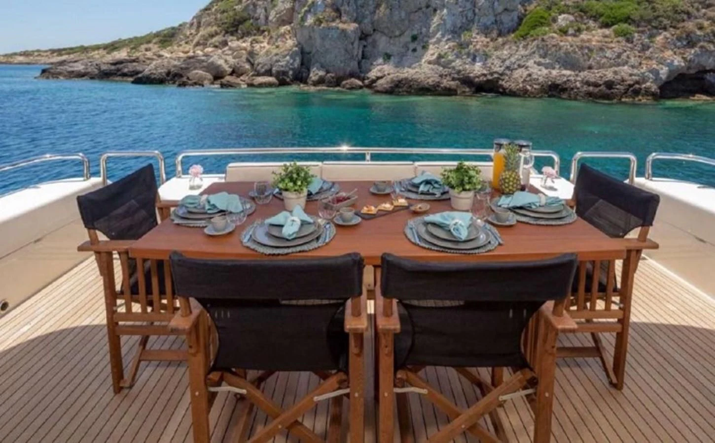 a table set for a meal on a beach aboard LEGEND Yacht for Sale