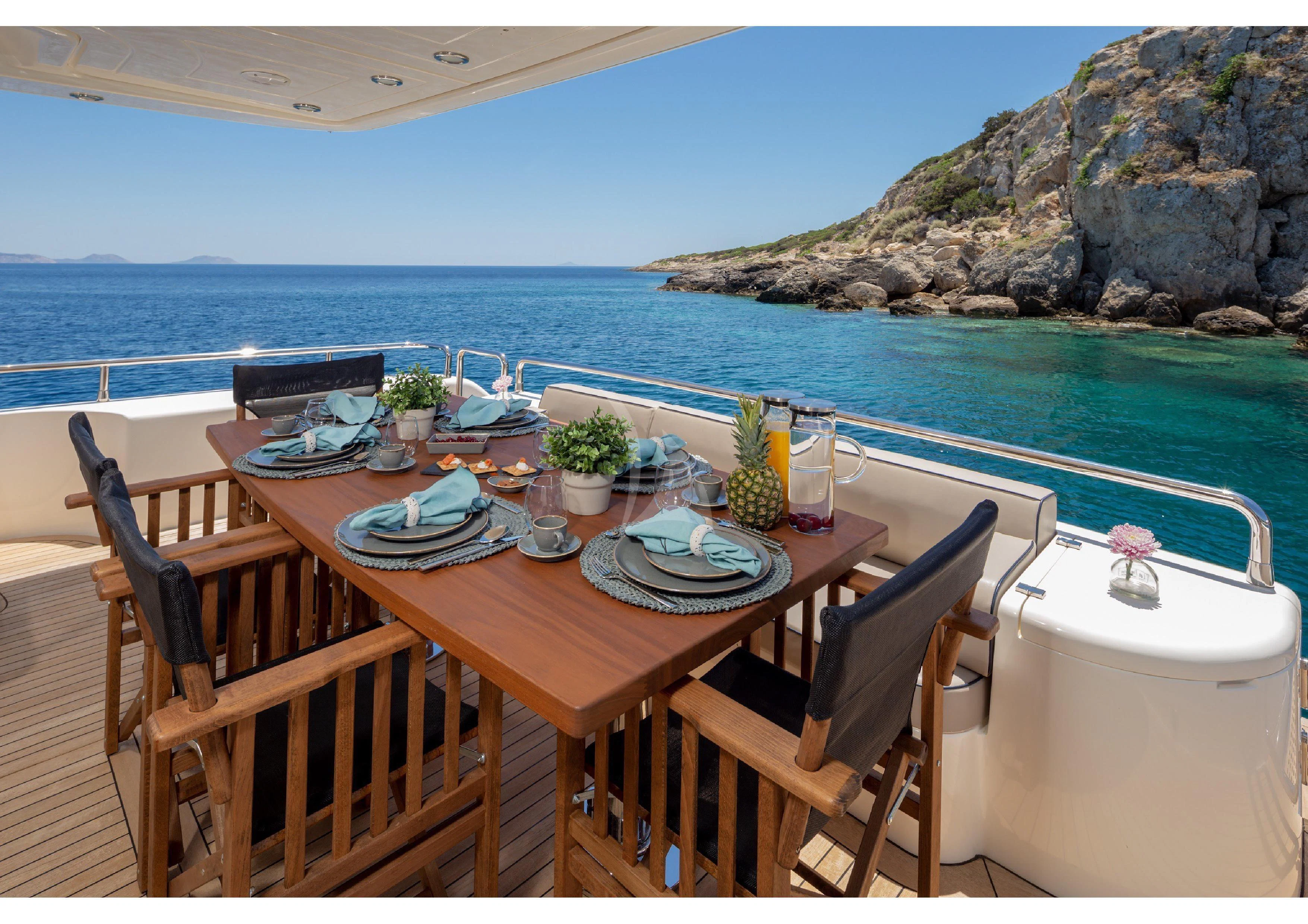 a table set for a meal on a balcony overlooking the ocean aboard LEGEND Yacht for Sale