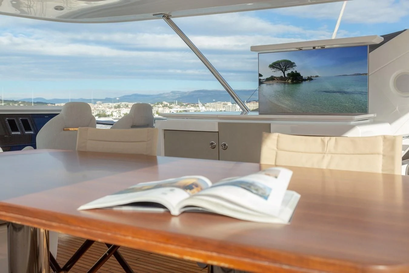 a table with a book and a laptop on it aboard SOLSTICE Yacht for Sale