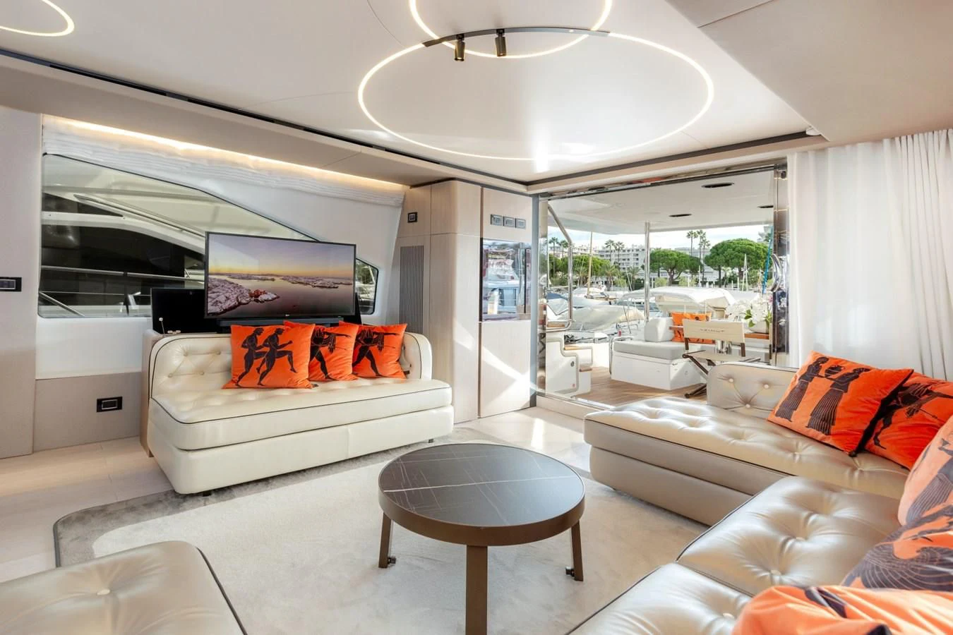 a living room with a white couch and a large window aboard SOLSTICE Yacht for Sale