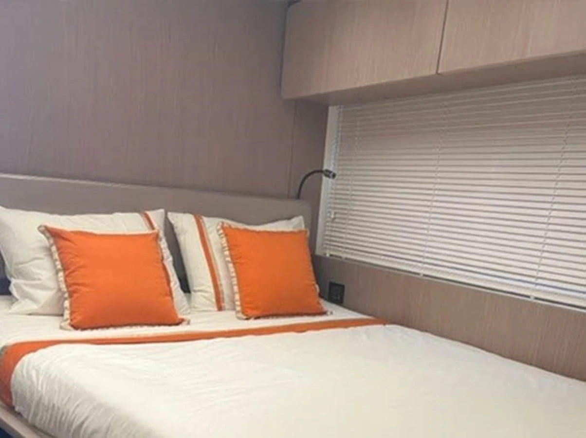 a bed with orange pillows aboard SOLSTICE Yacht for Sale