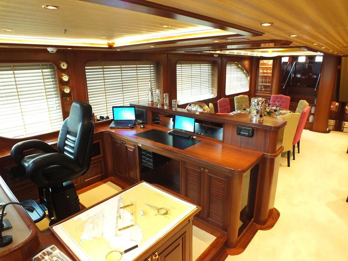 a large kitchen with a bar and chairs aboard CLEAR EYES Yacht for Sale