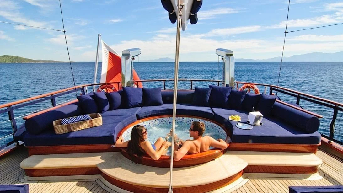 a man and woman sitting in a boat on the water aboard CLEAR EYES Yacht for Sale