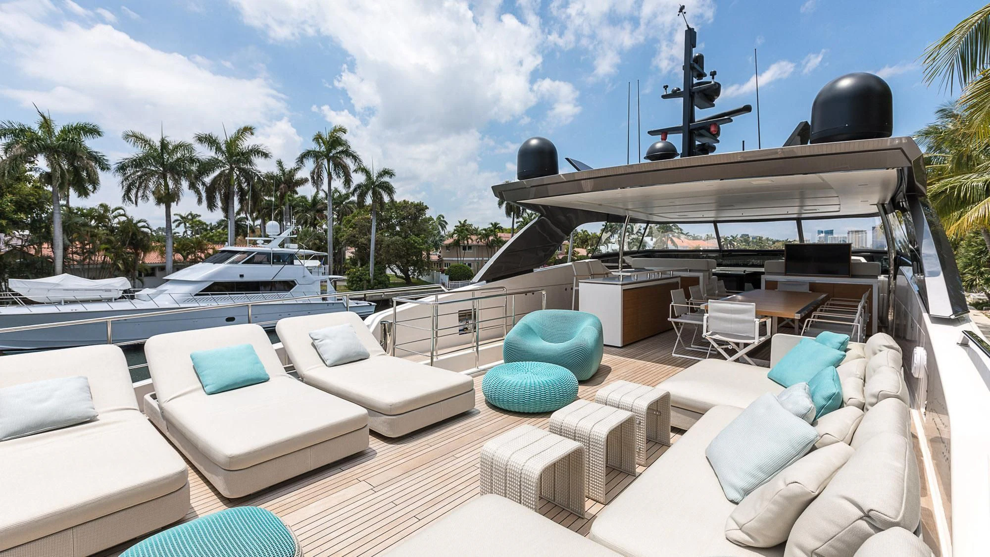 a deck with a pool and lounge chairs and a large white boat aboard CLEAR EYES Yacht for Sale