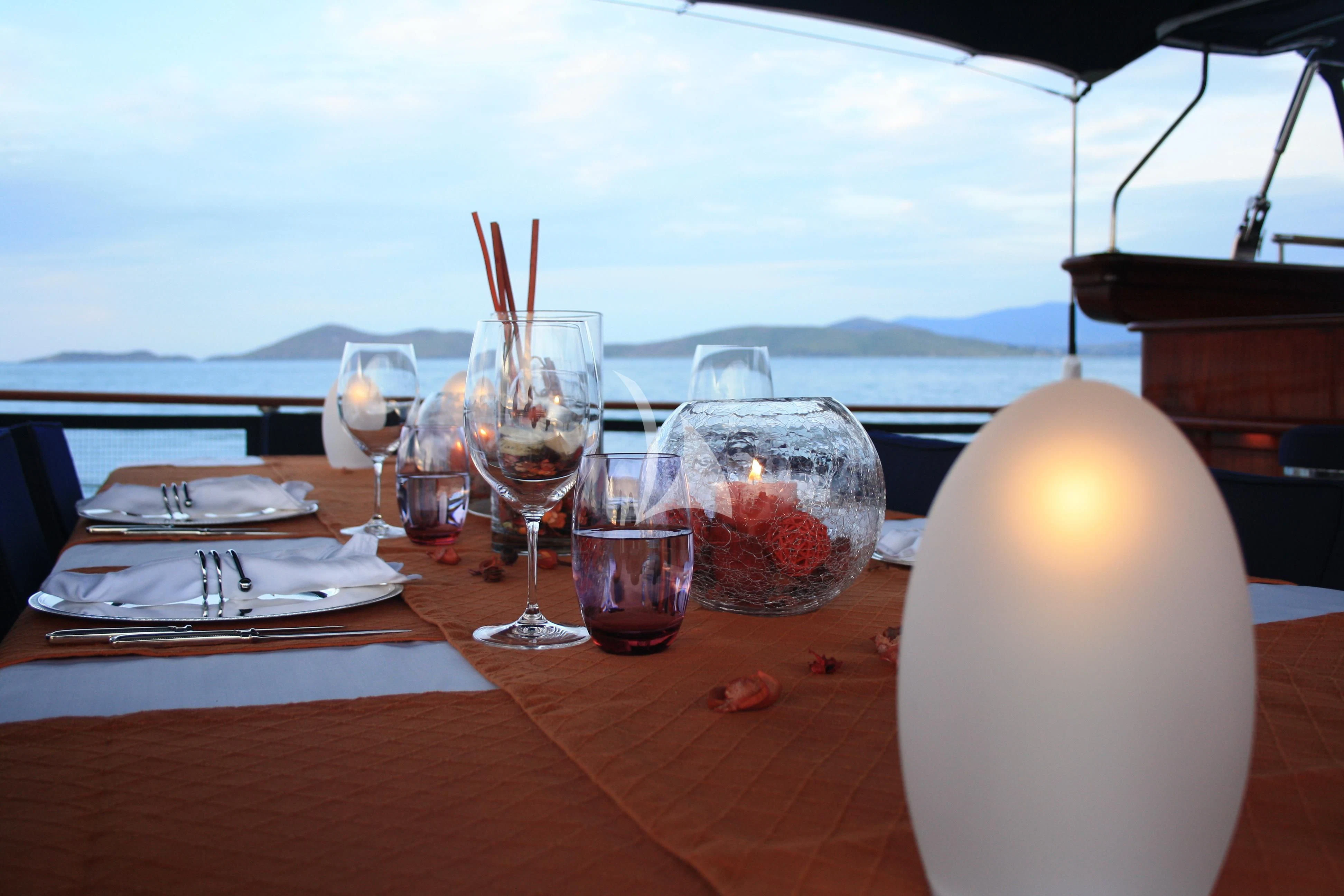 a table with wine glasses and a candle on it aboard CLEAR EYES Yacht for Sale
