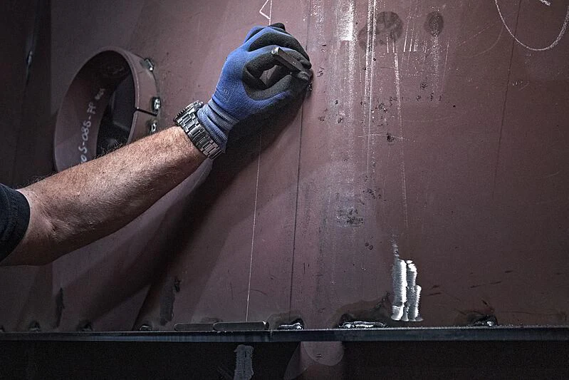 a person using a tool to drill a hole in a wall aboard IRIS BLUE Yacht for Sale
