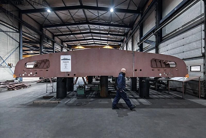 a person walking next to a large submarine in a warehouse aboard IRIS BLUE Yacht for Sale