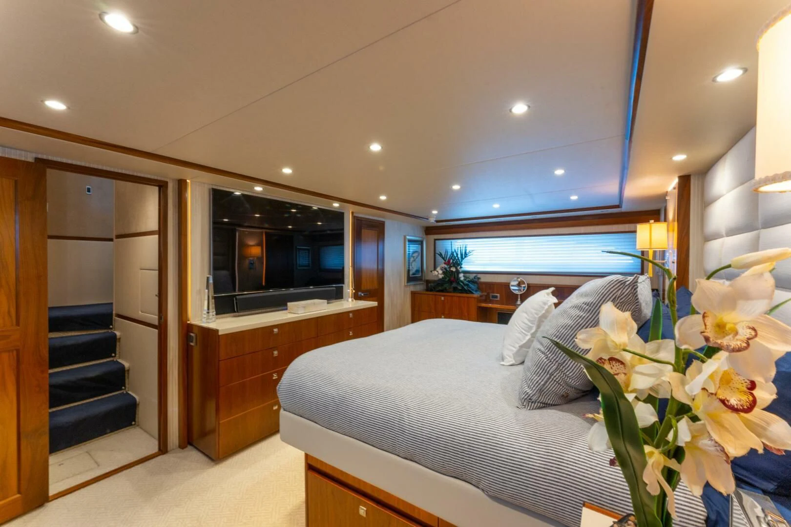 a bedroom with a bed and a television aboard HIGH COTTON Yacht for Sale