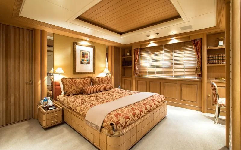 a bedroom with a bed and a bookcase aboard HARMONY Yacht for Sale