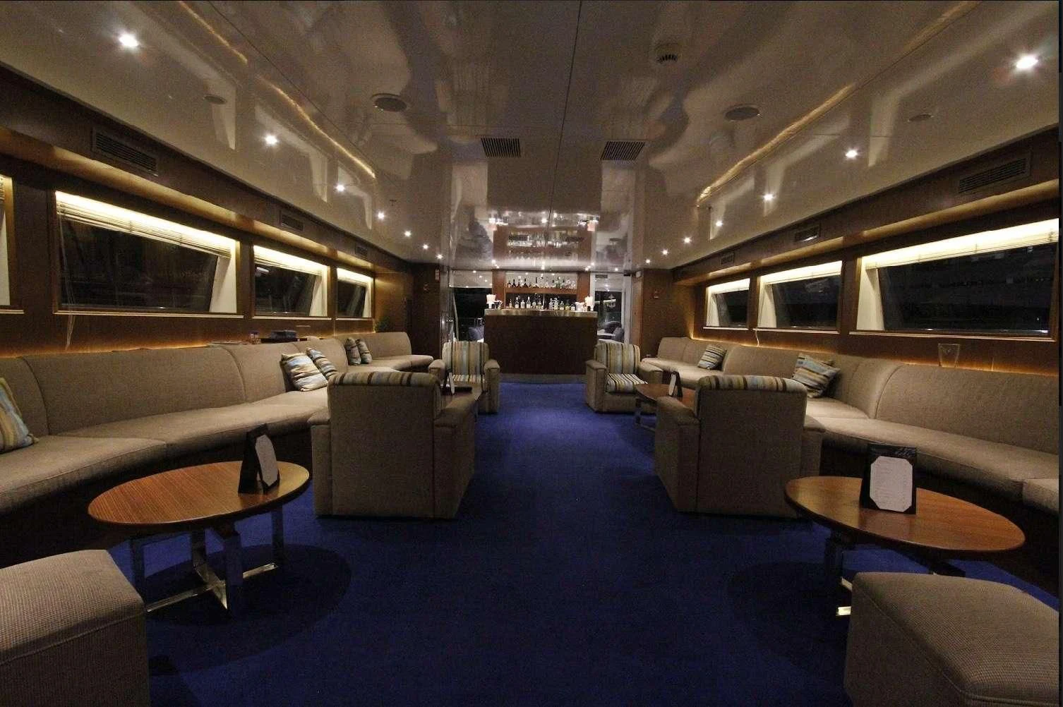 a room with couches and tables aboard HARMONY Yacht for Sale