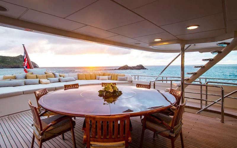a table set for a meal on a deck overlooking the ocean aboard HARMONY Yacht for Sale