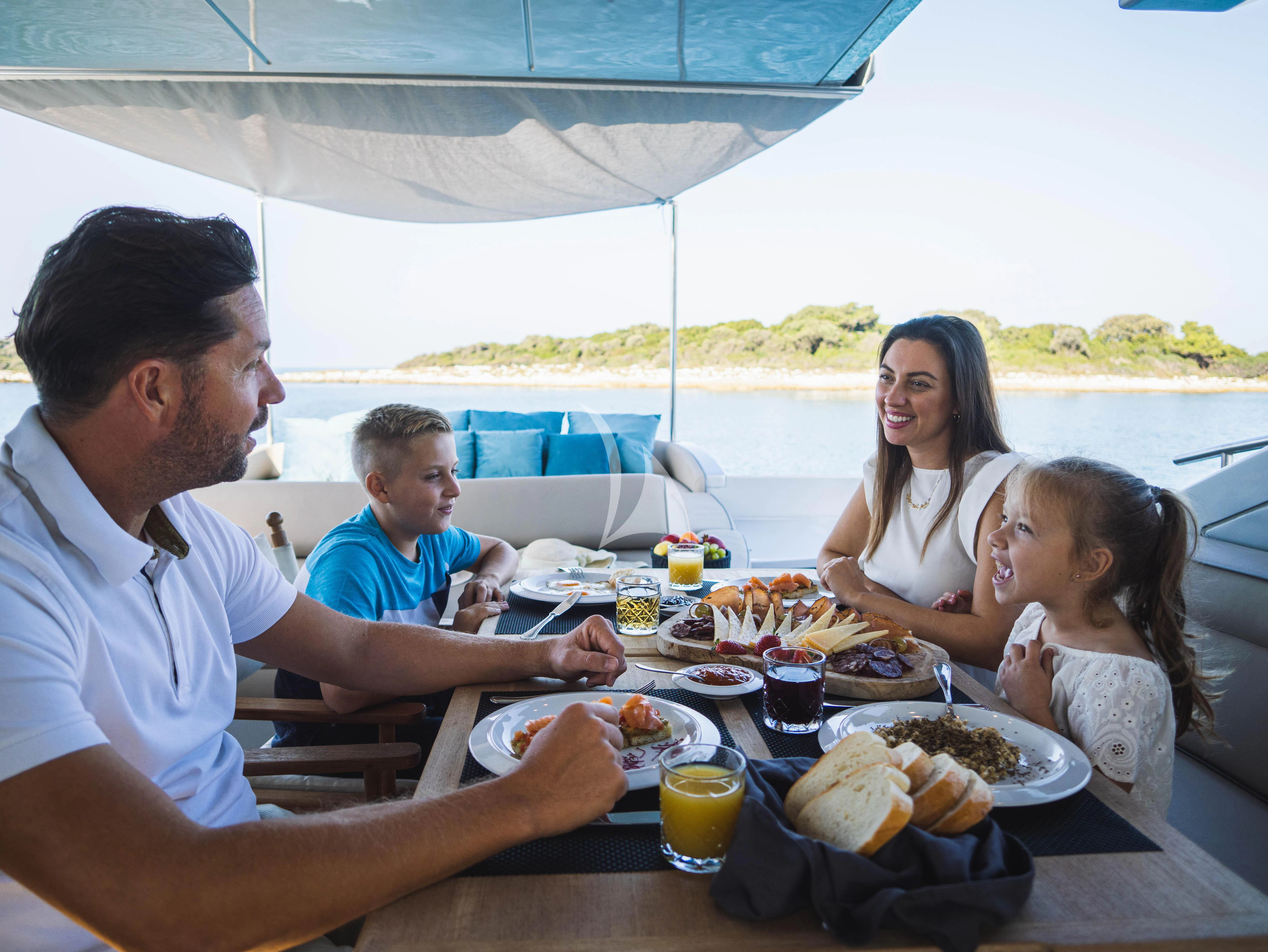 a family eating at a table aboard FALCH Yacht for Charter