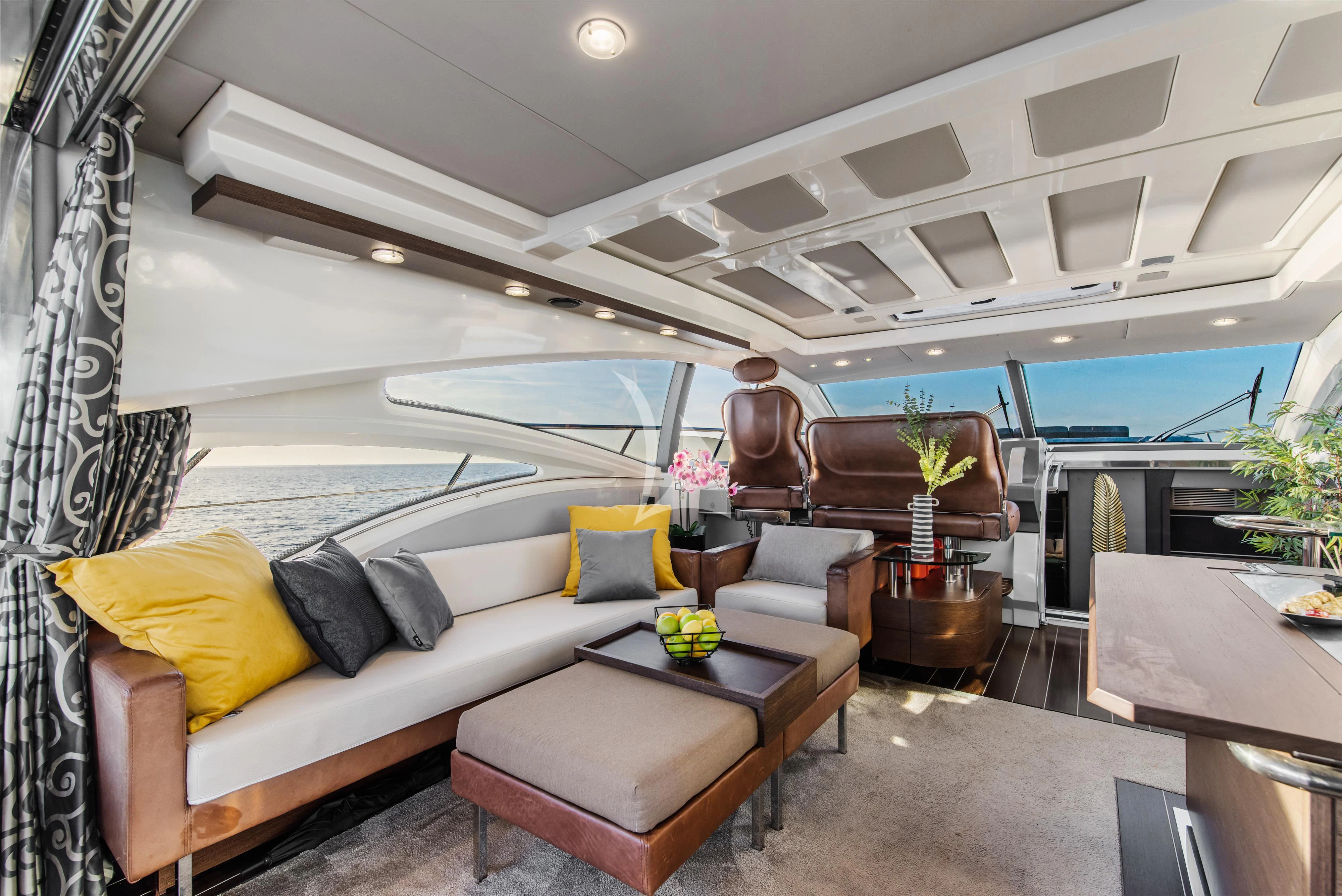 a living room with a large white lounge chair and a large swimming pool aboard FALCH Yacht for Charter