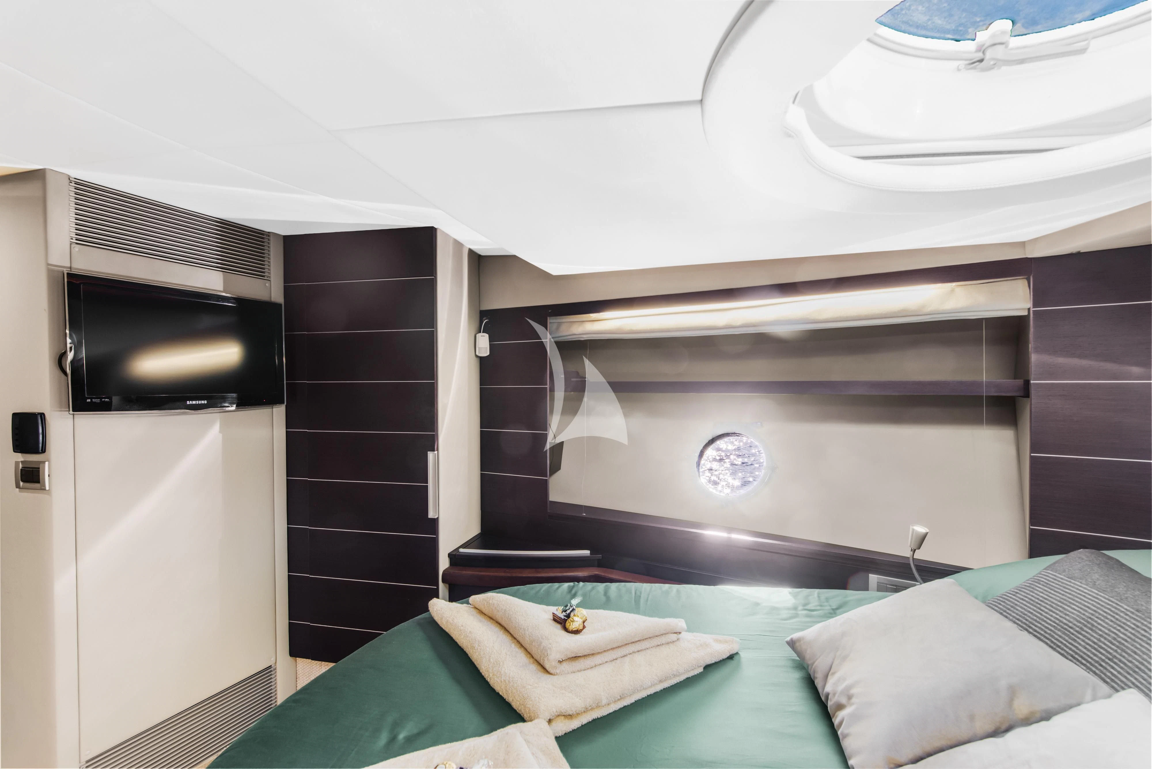 a room with a bed and a television aboard FALCH Yacht for Charter
