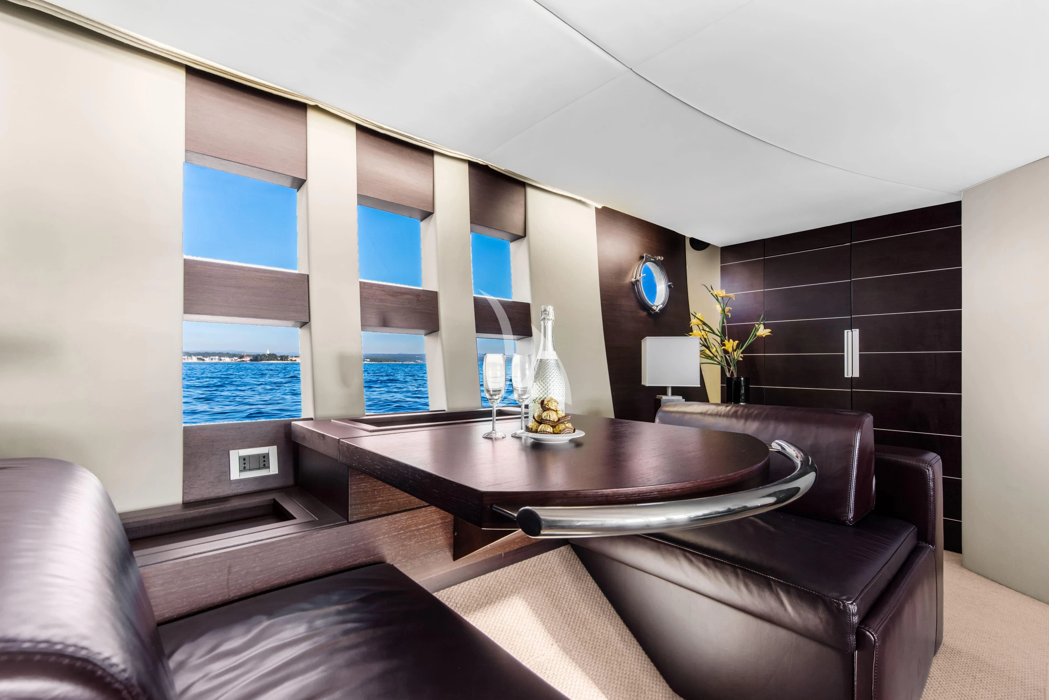 a room with a table and couches aboard FALCH Yacht for Charter