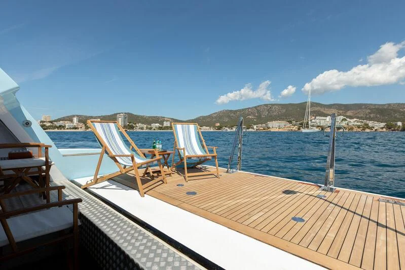 a deck with chairs on it by the water aboard CHECKMATE Yacht for Charter