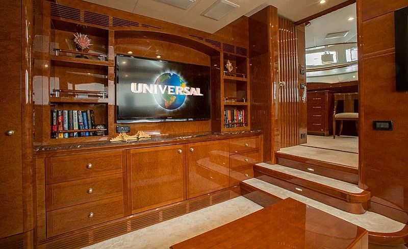 a room with a tv and bookshelves aboard CHECKMATE Yacht for Charter