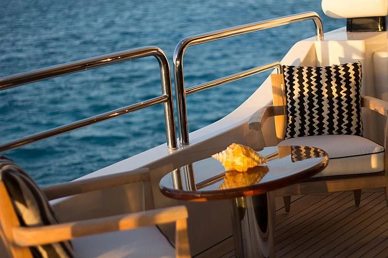 a table with a plate of food on it and chairs on the side aboard CHECKMATE Yacht for Charter