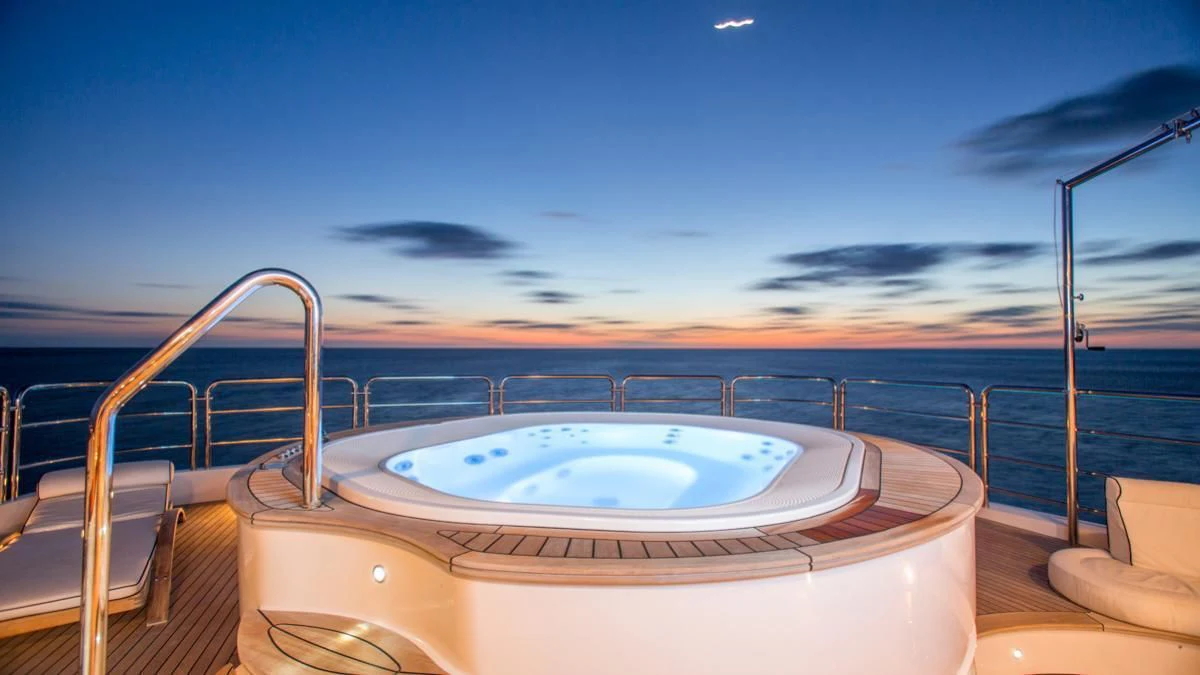 a large pool with a large white round table and chairs on a sunny day aboard CHECKMATE Yacht for Charter