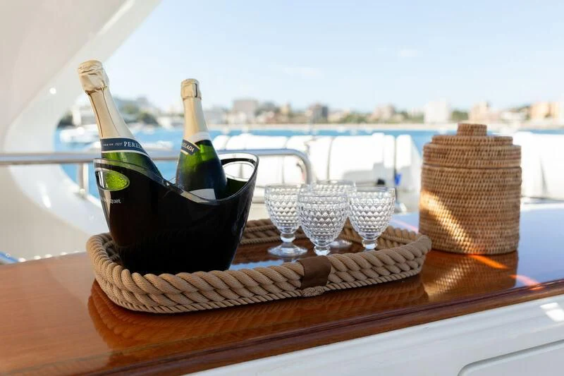 a bottle of champagne and a glass of champagne on a table aboard CHECKMATE Yacht for Charter