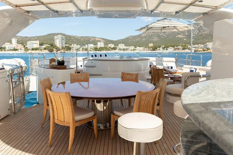 a table and chairs on a deck overlooking a body of water aboard CHECKMATE Yacht for Charter