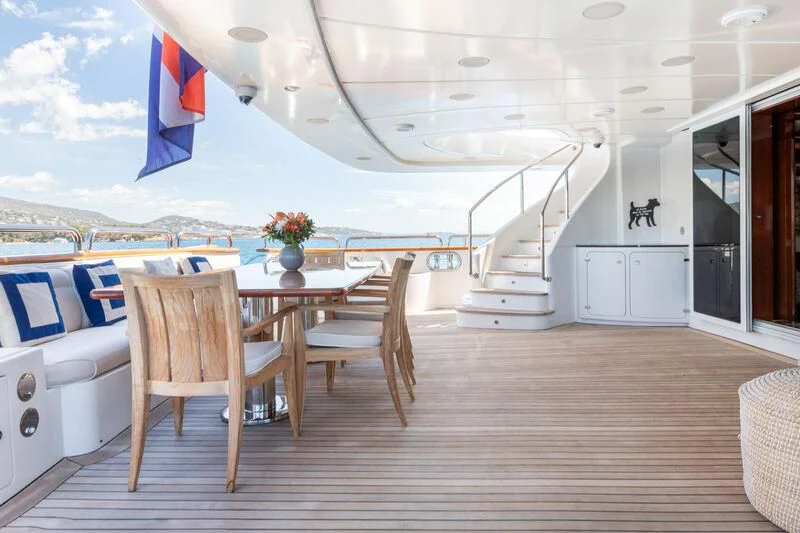 a large white lounge chair on a wooden deck next to a white lounge chair and a blue and aboard CHECKMATE Yacht for Charter