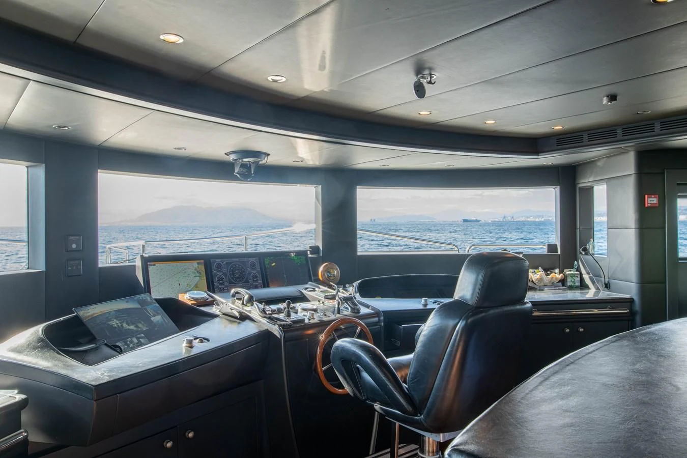 a room with a piano and a large window aboard CHECKMATE Yacht for Charter