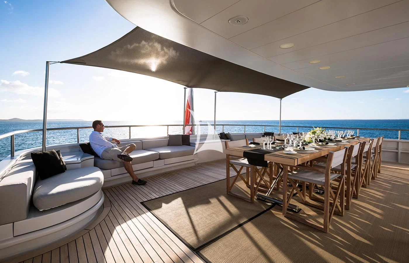 a person sitting on a couch on a deck overlooking the ocean aboard MARIU Yacht for Sale