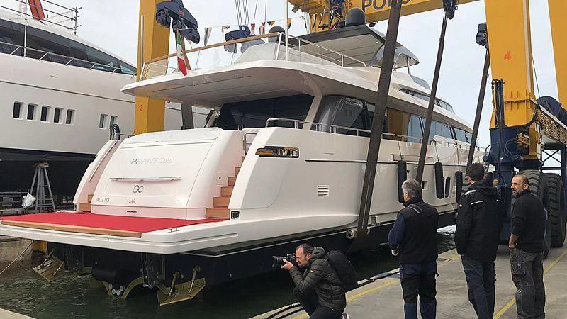a group of people standing next to a helicopter aboard PHANTOM Yacht for Sale