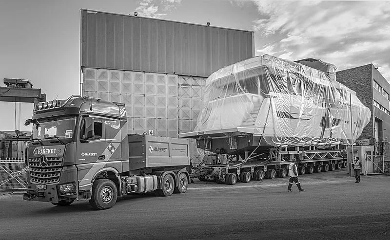 a large truck carrying a large satellite dish aboard BADE Yacht for Sale