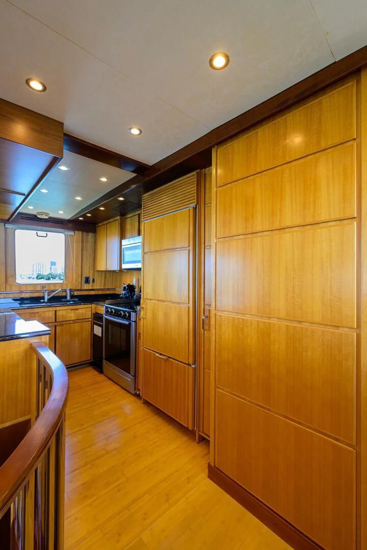 a kitchen with wooden cabinets aboard ELECTRA Yacht for Sale