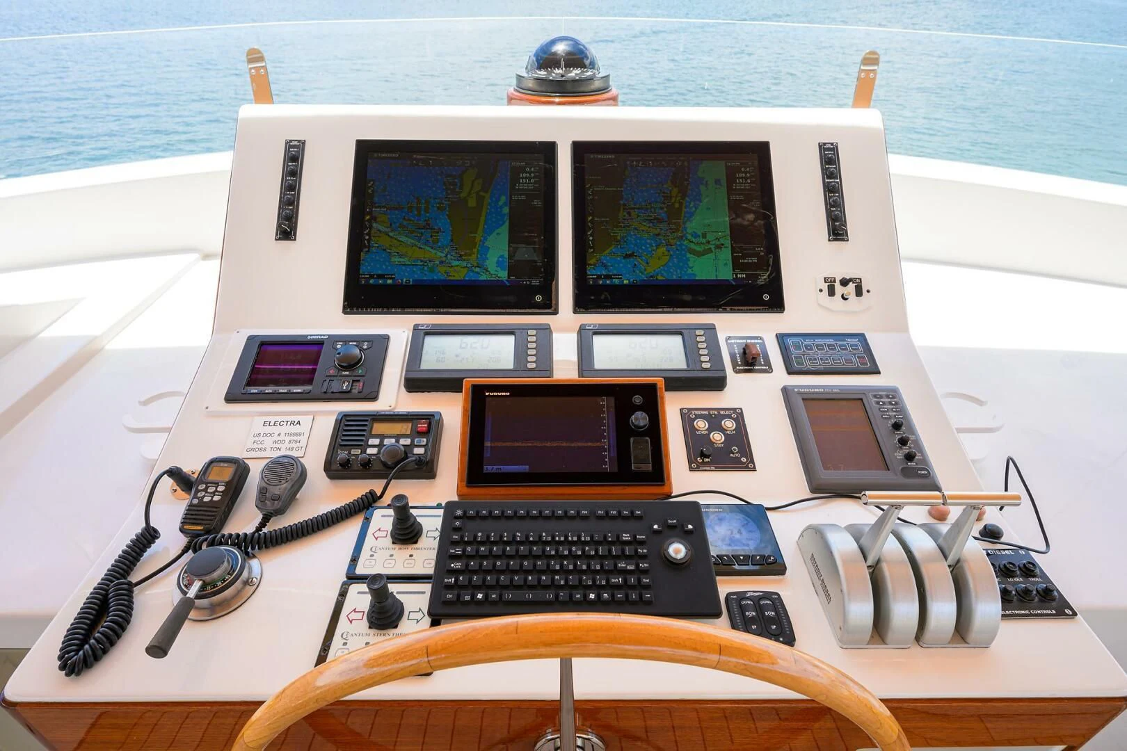 a laptop with headphones and a game controller on a table aboard ELECTRA Yacht for Sale