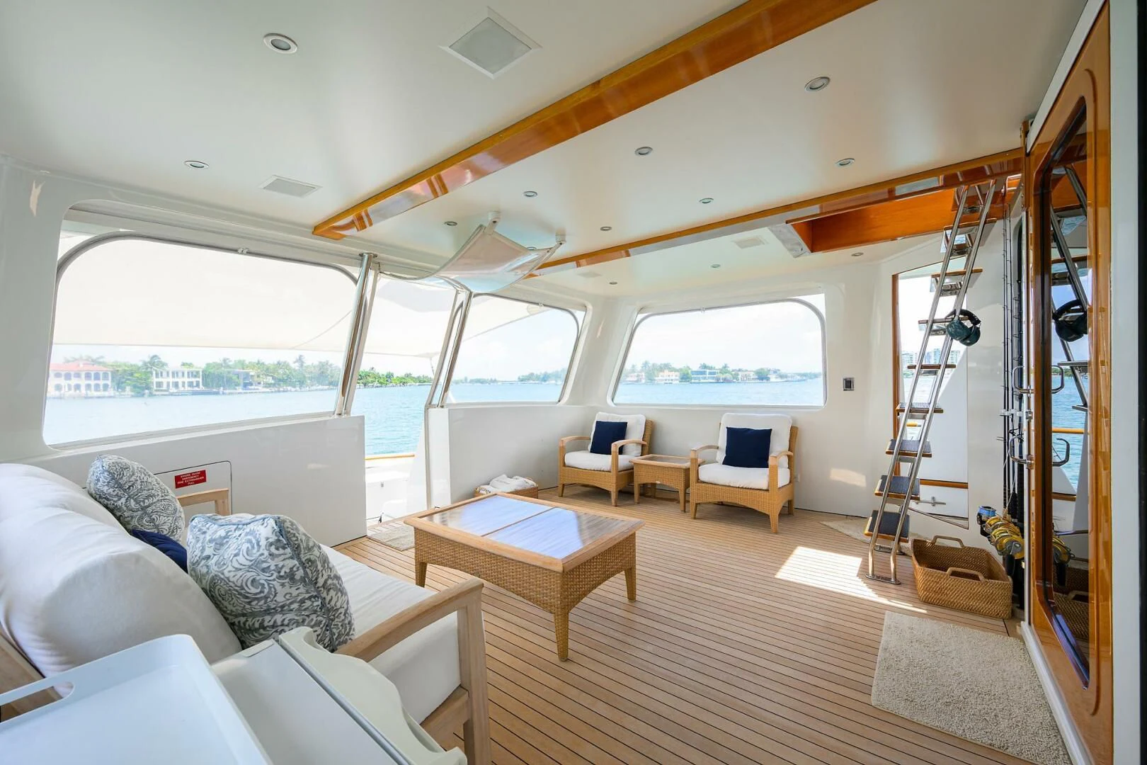 a room with a large window and a table with chairs and a ladder aboard ELECTRA Yacht for Sale