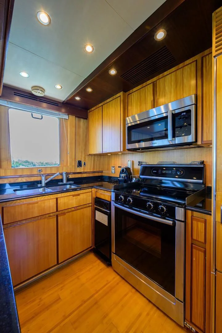 a kitchen with wooden cabinets aboard ELECTRA Yacht for Sale
