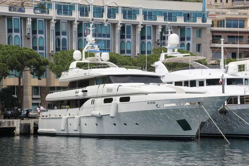 a white yacht docked in a harbor aboard THEOLINA Yacht for Sale