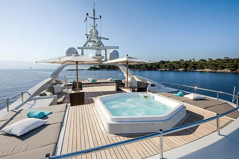 a deck with a large white boat on it and a white umbrella on it aboard THEOLINA Yacht for Sale