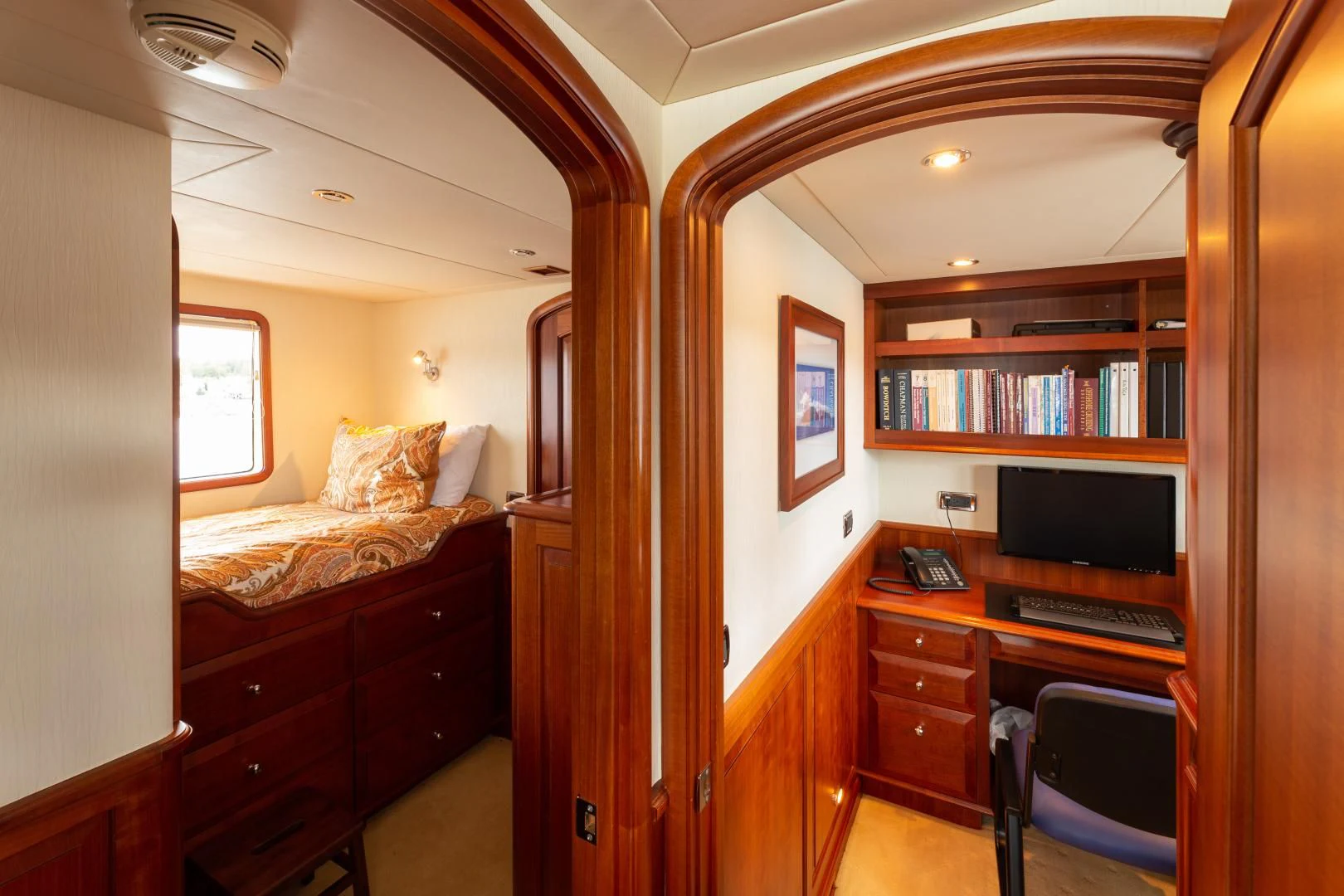 a room with a bed and desk aboard ISLANDER Yacht for Sale