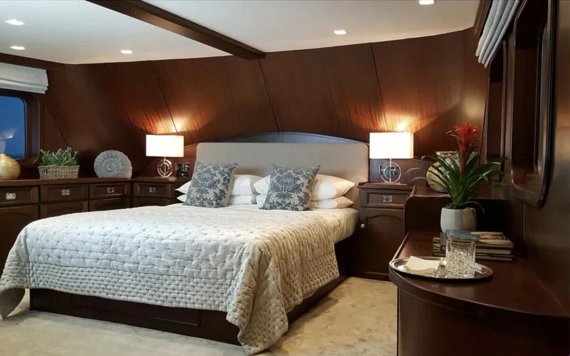 a bed with a white comforter and pillows in a hotel room aboard TRAFALGAR Yacht for Sale