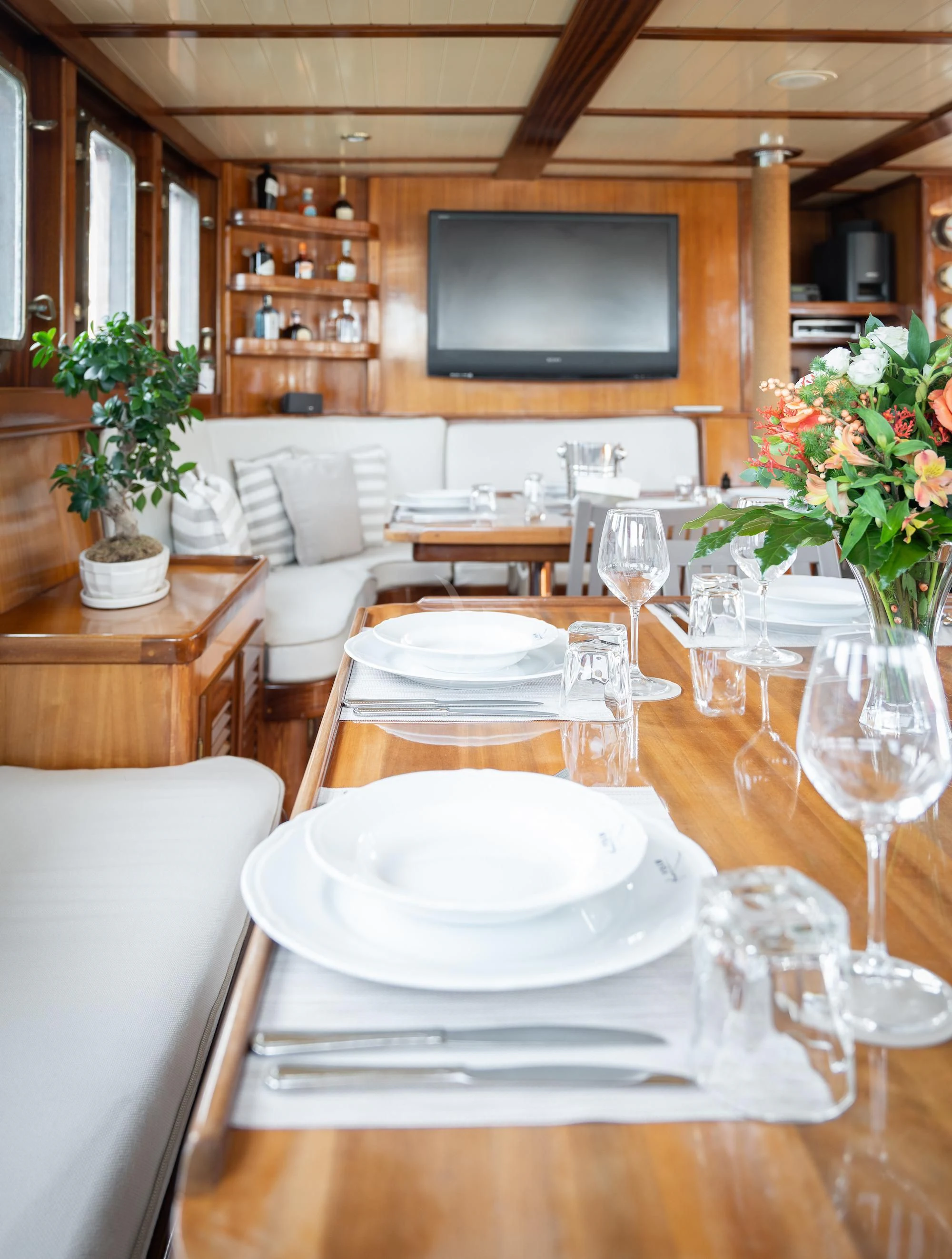 a table with plates and glasses aboard MYRA Yacht for Sale