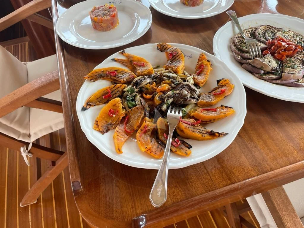a table with plates of food aboard MYRA Yacht for Sale