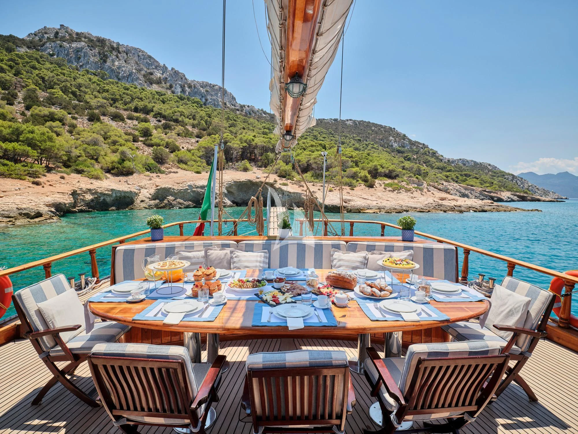 a table with food on it by a body of water aboard MYRA Yacht for Sale