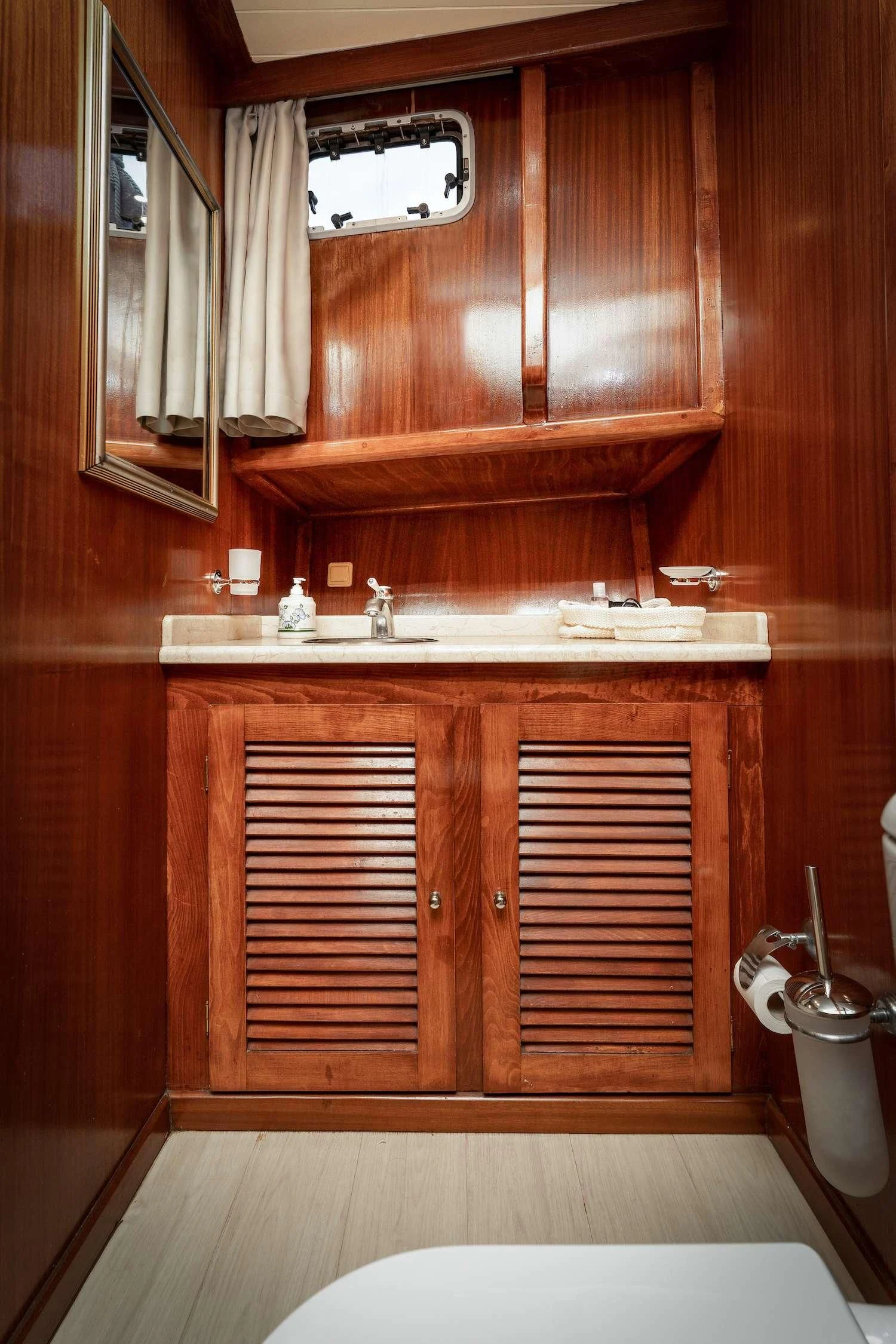 a bathroom with wooden cabinets aboard MYRA Yacht for Sale