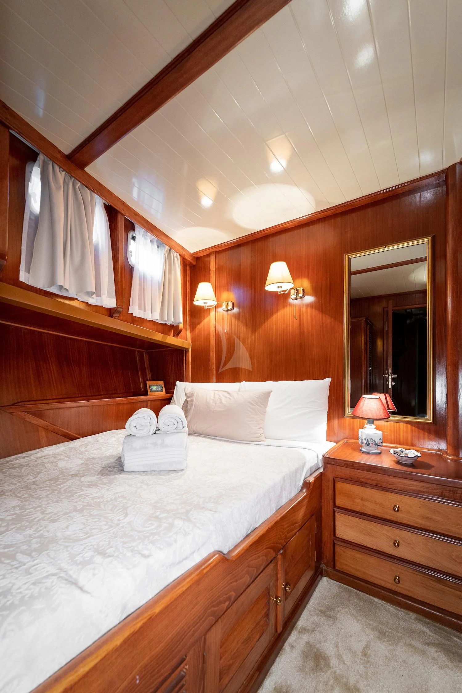 a bedroom with a bed and a mirror aboard MYRA Yacht for Sale