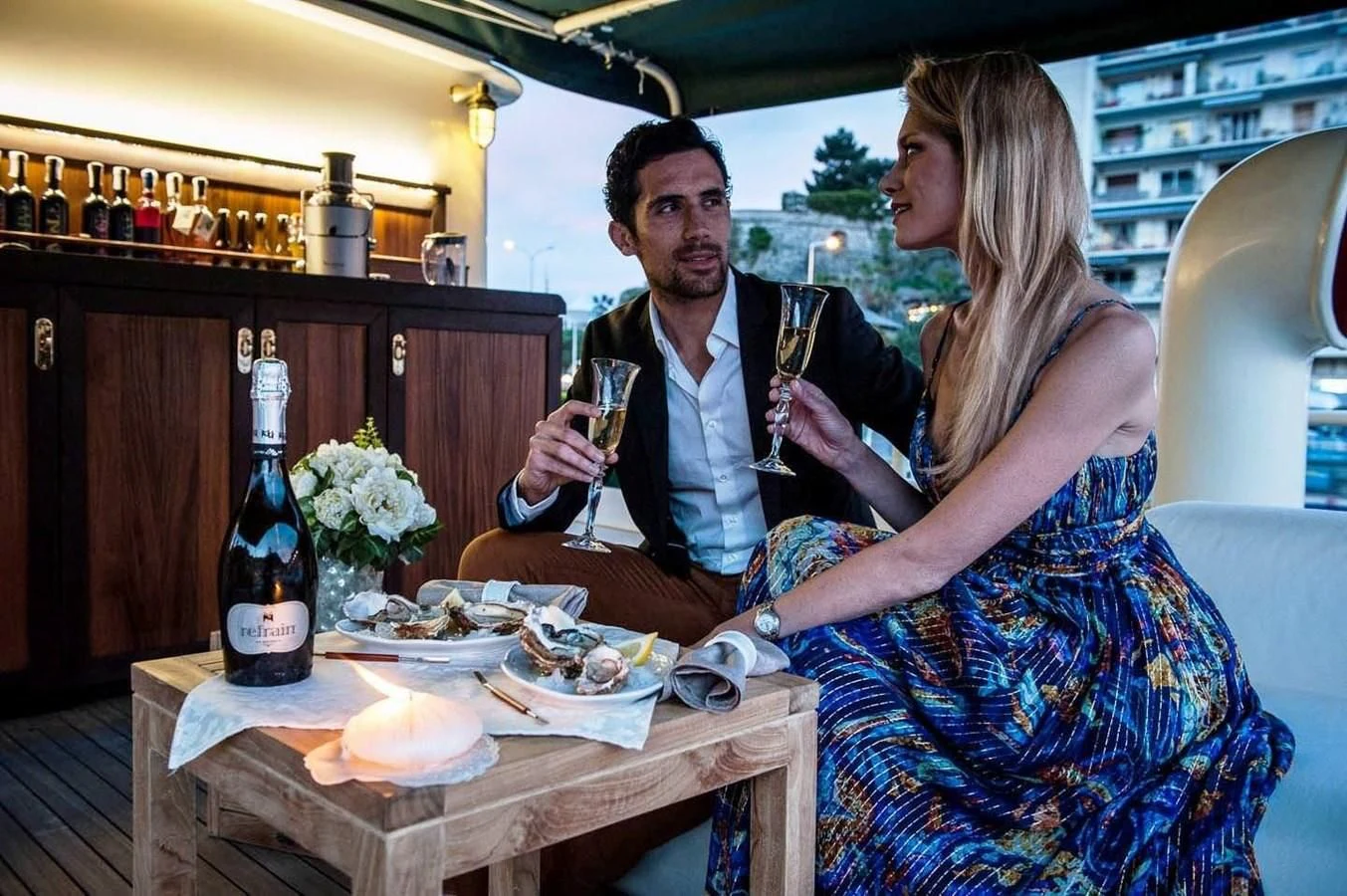 a man and woman sitting at a table with food and drinks aboard MARIA TERESA Yacht for Sale