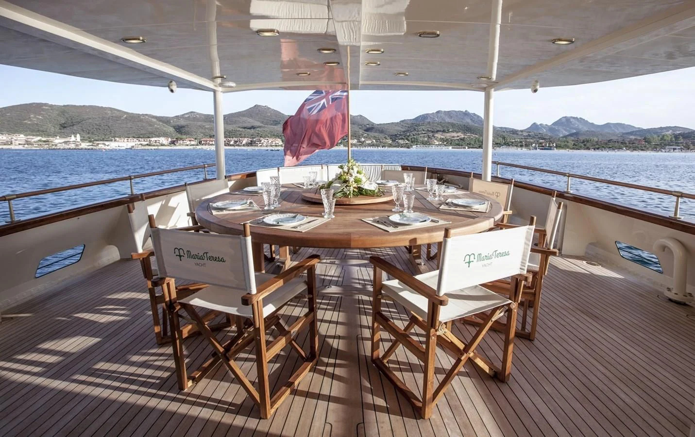 a table set for a meal on a deck overlooking the ocean aboard MARIA TERESA Yacht for Sale
