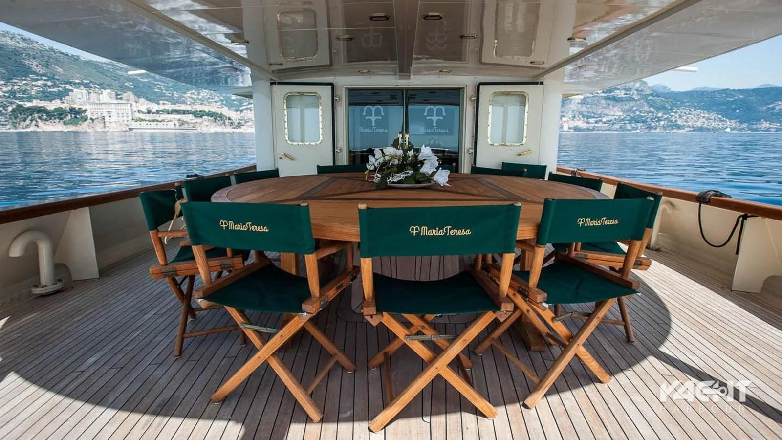 a table with green chairs on a deck overlooking a body of water aboard MARIA TERESA Yacht for Sale