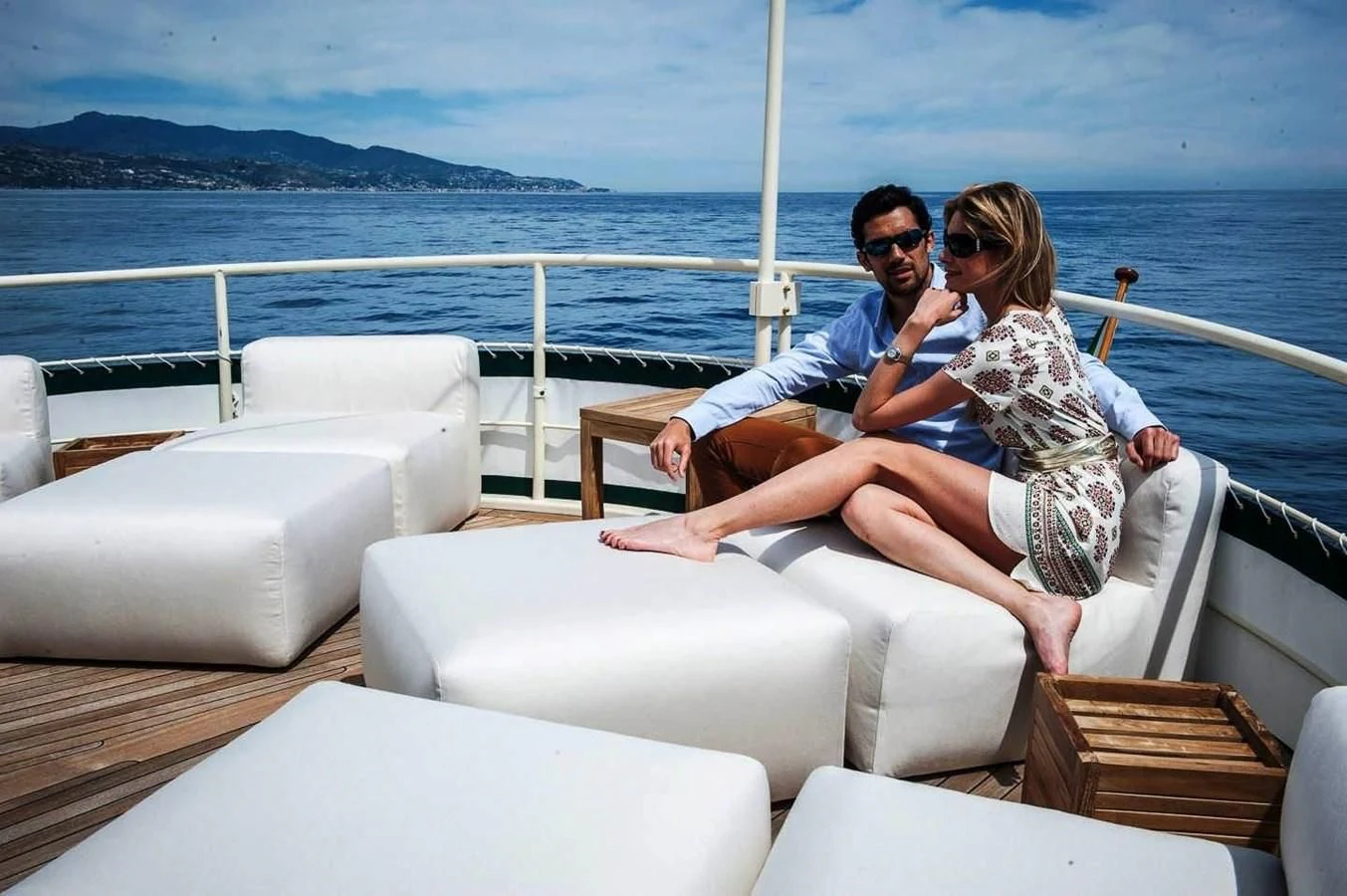 a man and woman sitting on a couch on a boat aboard MARIA TERESA Yacht for Sale